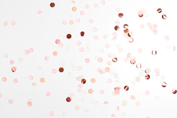 Happy New Year and Xmas or birthday festive composition. Golden pink confetti on white table background. Celebration, party concept. Flat lay, top view. Empty copy space.