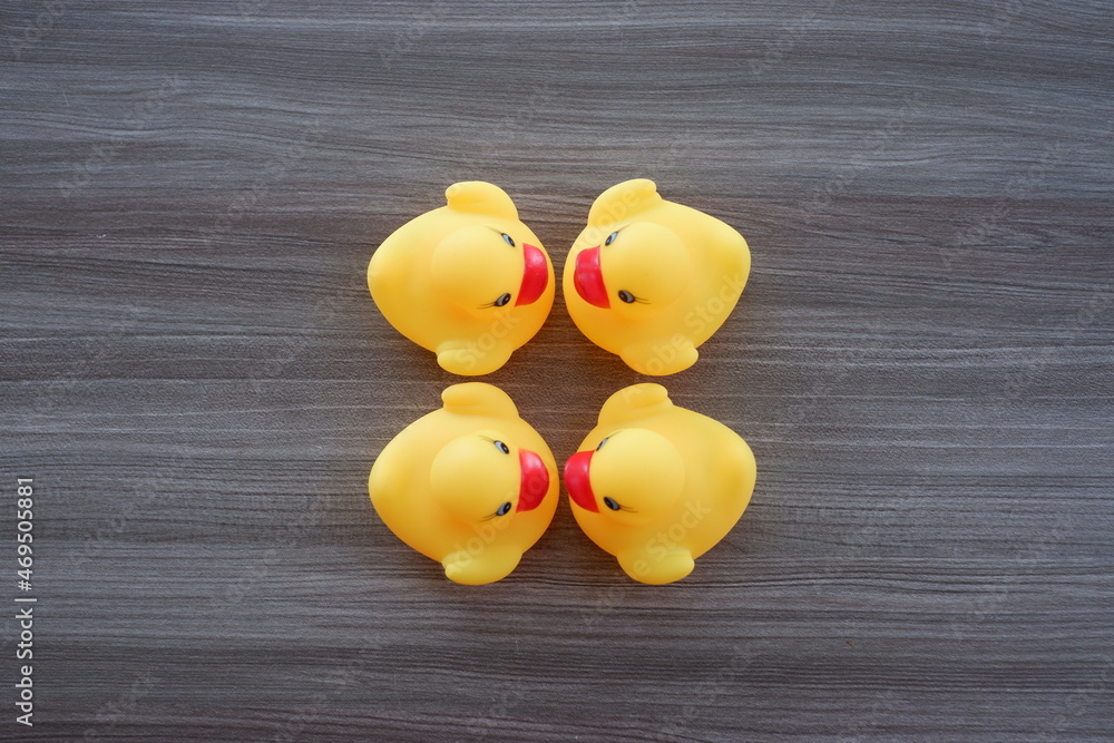 yellow duck toy on a wooden texture background with various