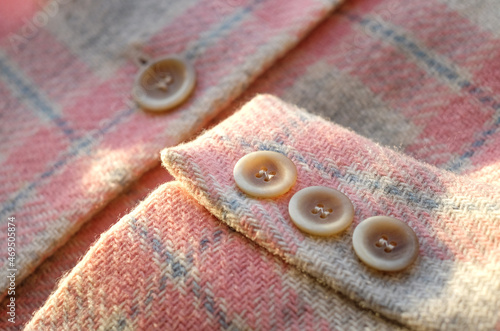 Buttons placed on a sleeve of wool jacket. Close up image. With sunlight