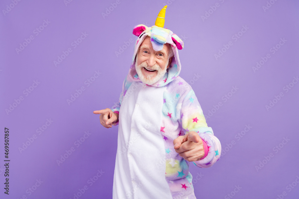 Photo of funky cool retired man nightwear overall smiling pointing finger you empty space isolated purple color background Photo of funky cool retired man nightwear overall smiling pointing finger you empty space isolated purple color background