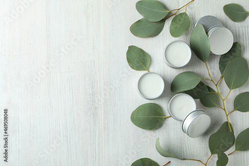 Eco lip balm and leaves on white wooden background