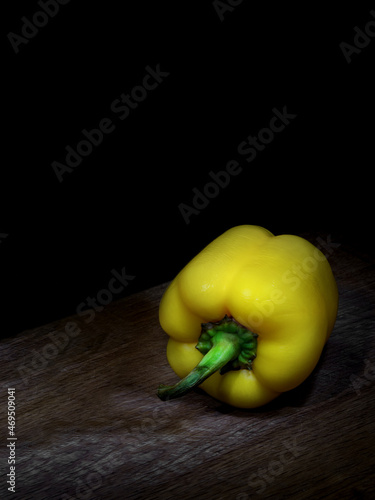 Yellow bell pepper on wooden board