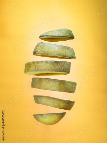 Chopped floating potato on orange background