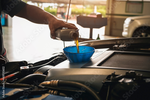 Auto mechanic changing oil at repair shop or service center.