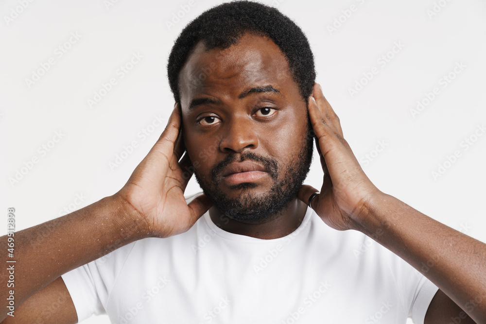 Black bristle man dressed in t-shirt covering his ears Black bristle man dressed in t-shirt covering his ears