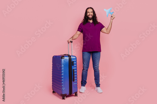 Photo of cheerful man hold tickets passport valise wear purple t-shirt isolated Fototapeta