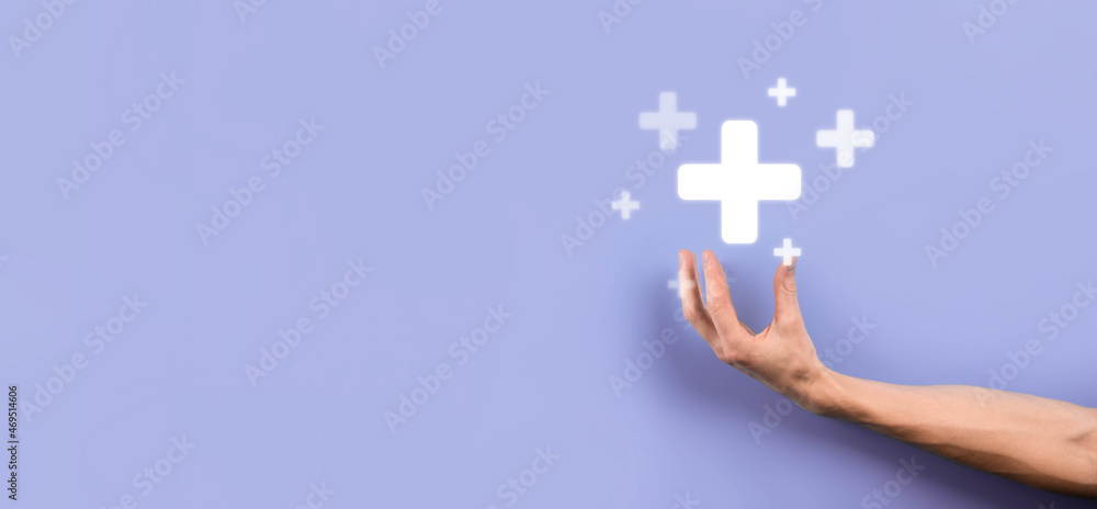 Obraz premium Businessman, man hold in hand offer positive thing such as profit, benefits, development, CSR represented by plus sign.The hand shows the plus sign
