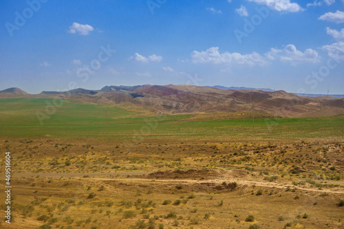 Deserted steppe, giving way to green pasture at the foot of the Gissar ridge. Shot in the Surkhandarya region of southern Uzbekistan