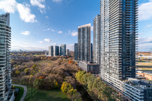 Drone Views of condos and Humber bay shores with brown trees tops Fall colours by Parklawn rd and lakeshore with blue skies and broken clouds 