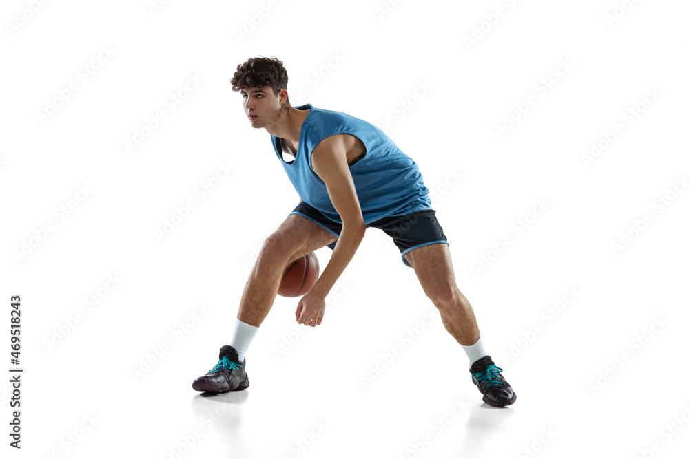 Full length portrait of basketball player practicing isolated on white studio background. Tall muscular athlete dribbling the ball. Full length portrait of basketball player practicing isolated on white studio background. Tall muscular athlete dribbling the ball.