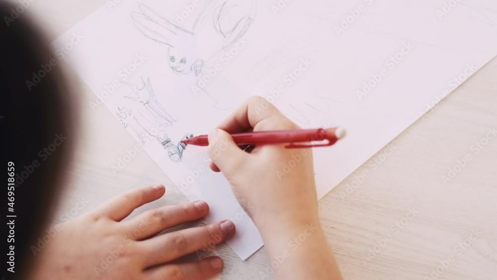 Cute picture. Kid painting. Art hobby. Unrecognizable child drawing on white paper with pencil sitting table. Cute picture. Kid painting. Art hobby. Unrecognizable child drawing on white paper with pencil sitting table.