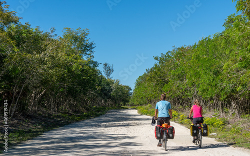 Canvas Print Two Cyclists on Forested Path Surrounded by Lush Greenery, Cuba