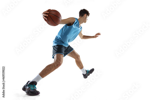 One professional basketball player in blue sports uniform training with ball isolated on white studio background.