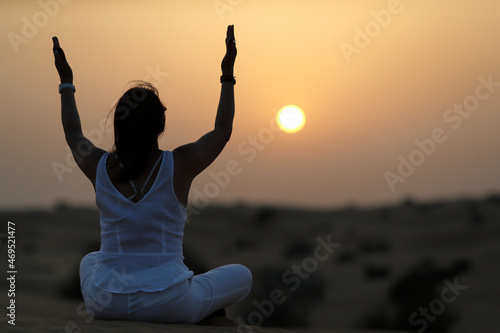 Sunset meditation in the desert at sunset, as concept for religion, faith, prayer and spirituality, Dubai, United Arab Emirates