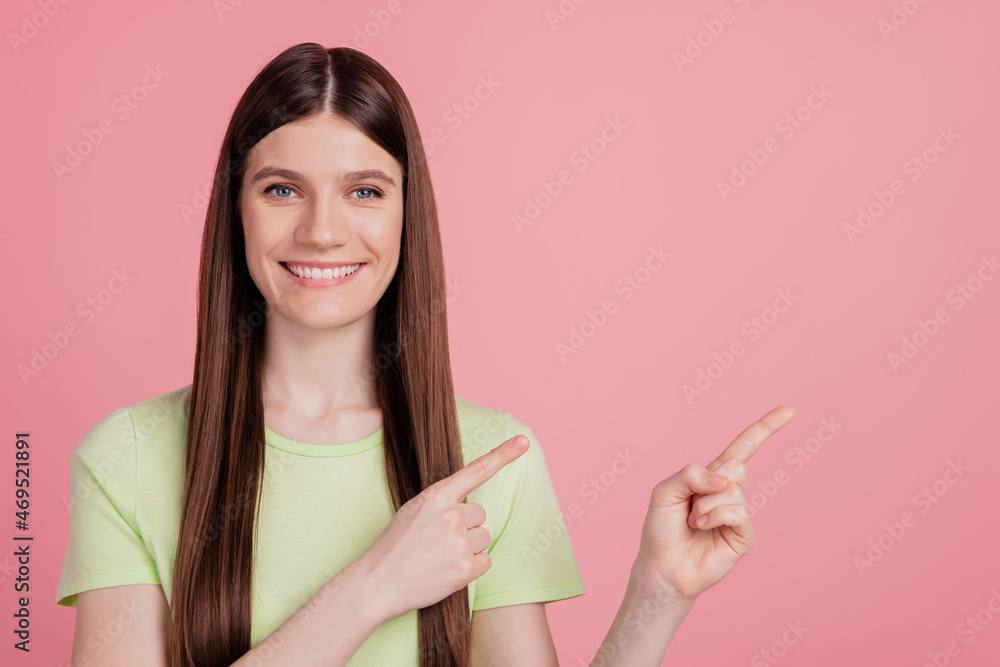 Photo portrait of girl happy positive smile pointing finger empty space isolated on pastel pink color background Photo portrait of girl happy positive smile pointing finger empty space isolated on pastel pink color background