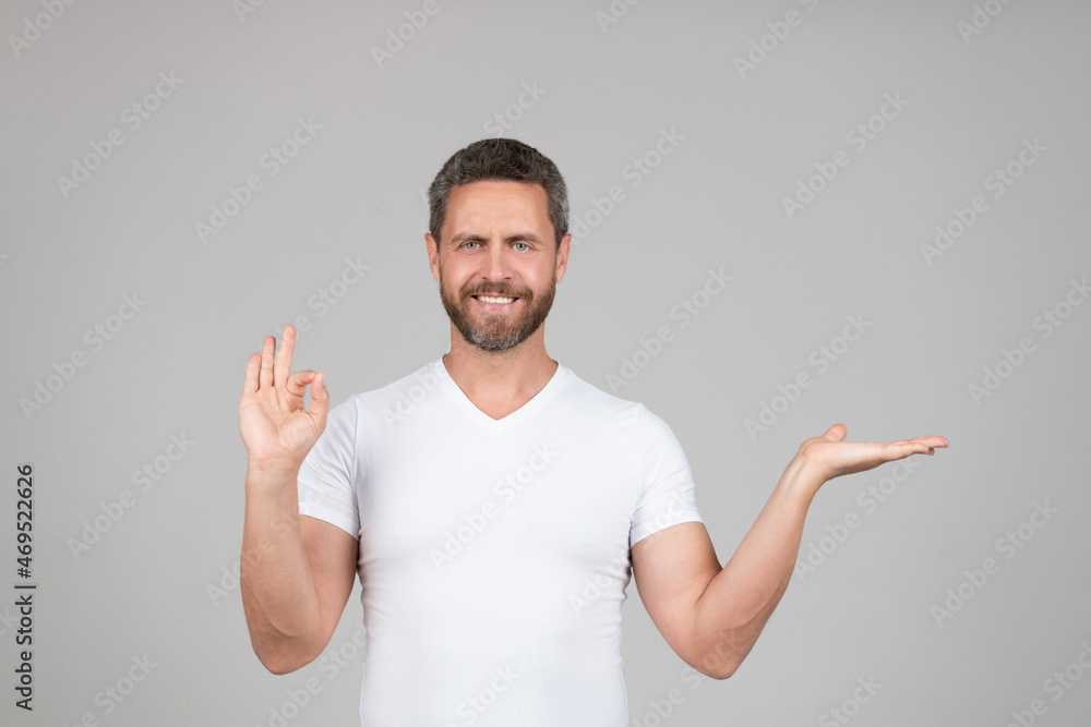Happy guy show open hand making OK ring gesture grey background copy space, presenting product Happy guy show open hand making OK ring gesture grey background copy space, presenting product