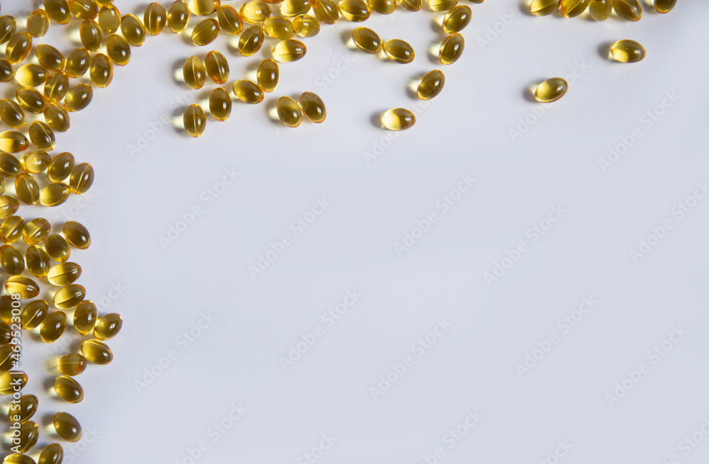 White frame background from tablets of gelatinous golden yellow capsules, vitamin D3. Beautiful colored golden vitamin D3. A bunch of vitamin D3. White frame background from tablets of gelatinous golden yellow capsules, vitamin D3. Beautiful colored golden vitamin D3. A bunch of vitamin D3.
