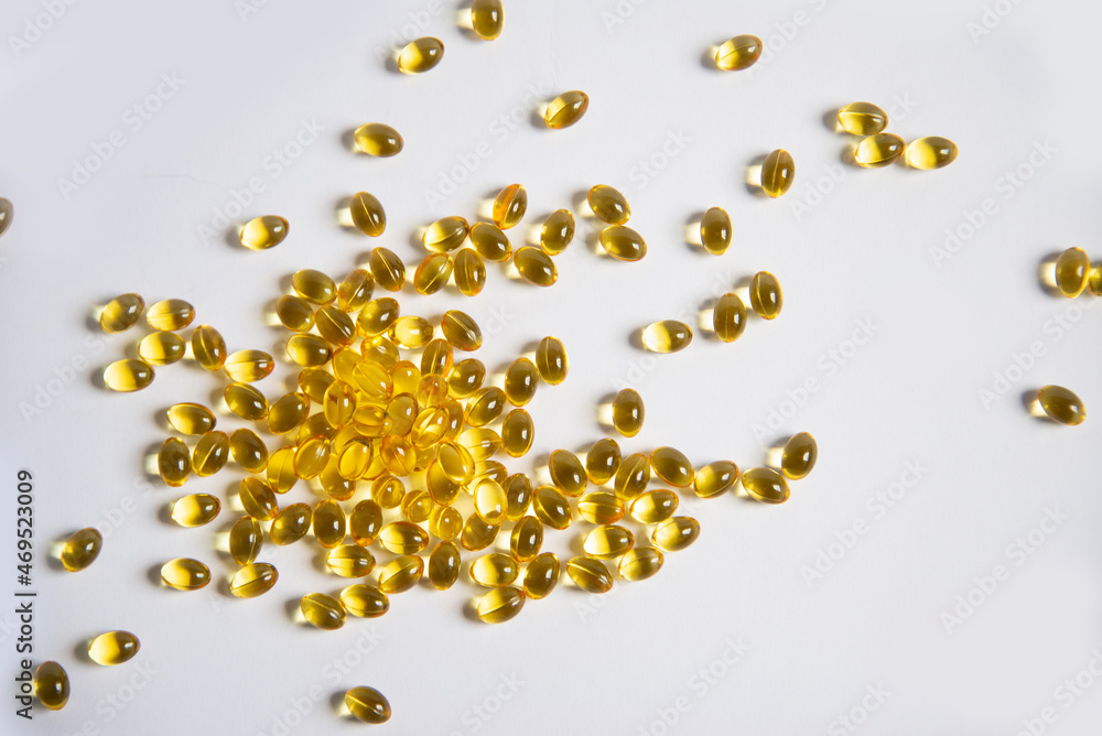 White background from tablets of gelatinous golden yellow capsules, vitamin D3. Beautiful colored golden vitamin D3 tablets, background, nutrition, nutritional supplements. A bunch of vitamin D3. White background from tablets of gelatinous golden yellow capsules, vitamin D3. Beautiful colored golden vitamin D3 tablets, background, nutrition, nutritional supplements. A bunch of vitamin D3.