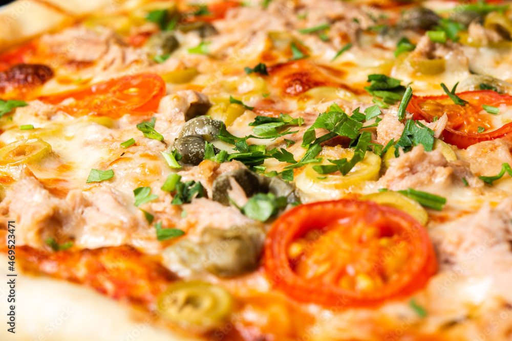 Delicious pizza close up, white plate on black background Delicious pizza close up, white plate on black background