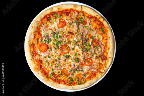 Delicious pizza close up, white plate on black background