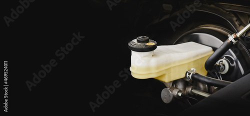 Brake fluid reservoir of car brake system with horizontal copy space on black background