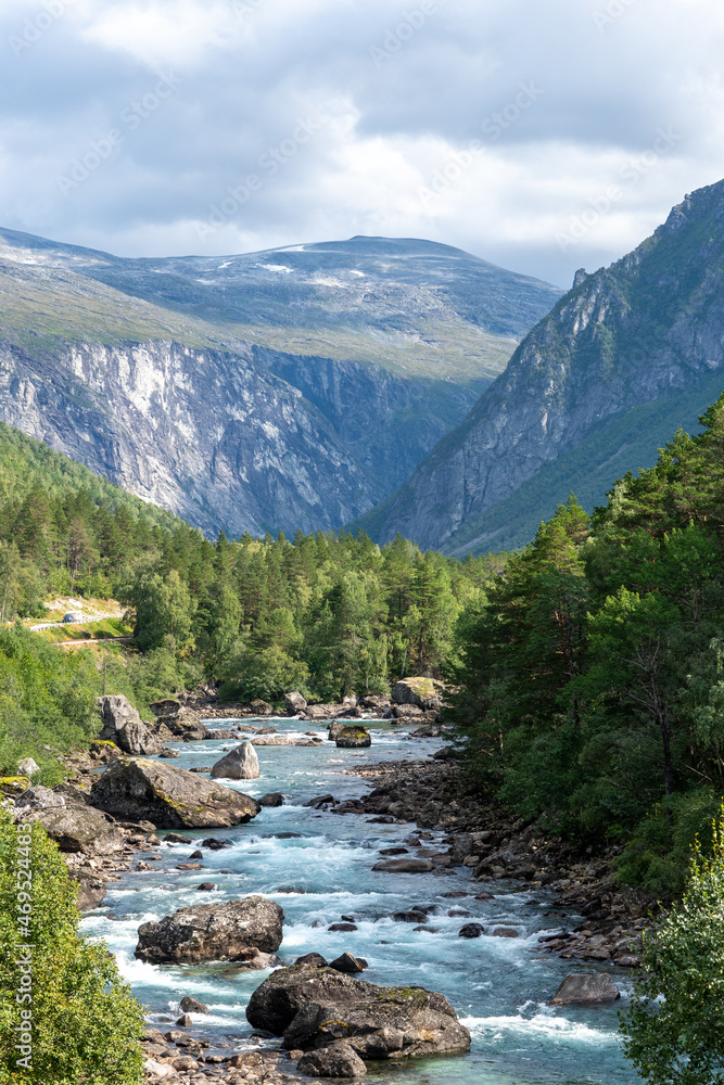 Verdant forest nestled between towering mountains in Norway, showcasing natural beauty. Verdant forest nestled between towering mountains in Norway, showcasing natural beauty.
