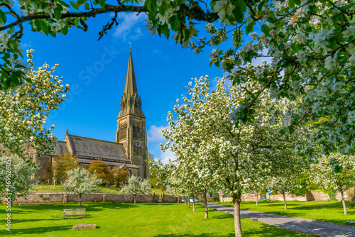 View of St. Peter's Church and spring blossom, Edensor Village, Chatsworth Park, Bakewell, Derbyshire photo