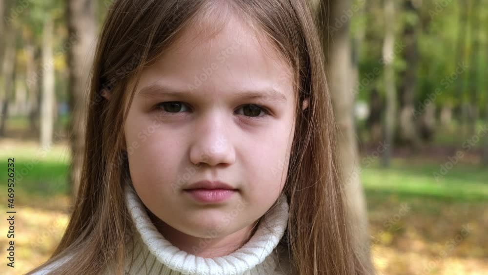 Portrait Thoughtful Little Girl Smiling Looking at Camera. Child in the Park on Sunny Day. Closeup. Face Kid outdoors Portrait Thoughtful Little Girl Smiling Looking at Camera. Child in the Park on Sunny Day. Closeup. Face Kid outdoors