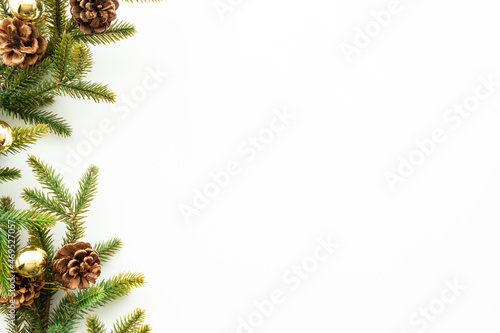 White table with Christmas decoration including pine branches and pine cones with golden balls. Merry Christmas and happy new year concept. Top view with copy space, flat lay.