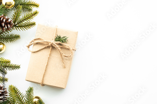 Beautiful Christmas background with gift box, decorate with pine branch and pine cone over white background. Top view with copy space, flay lay.
