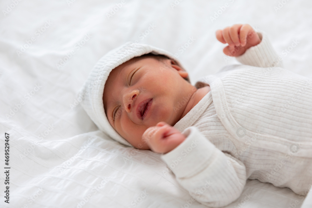Top view happy newborn baby lying sleeps on a white blanket comfortable and safety.Cute Asian newborn sleeping and napping on bed.Newborn Baby photography concept Top view happy newborn baby lying sleeps on a white blanket comfortable and safety.Cute Asian newborn sleeping and napping on bed.Newborn Baby photography concept