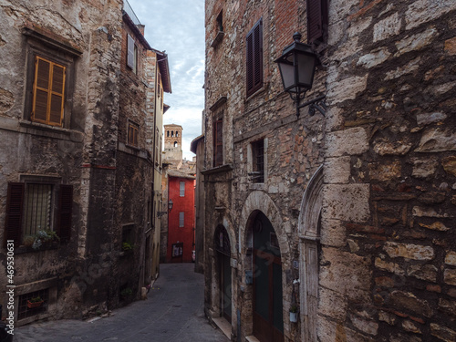 A typical medieval alley in Narni's old town, with a view of the bell tower of the Cathedral, Narni, Umbria, Italy photo