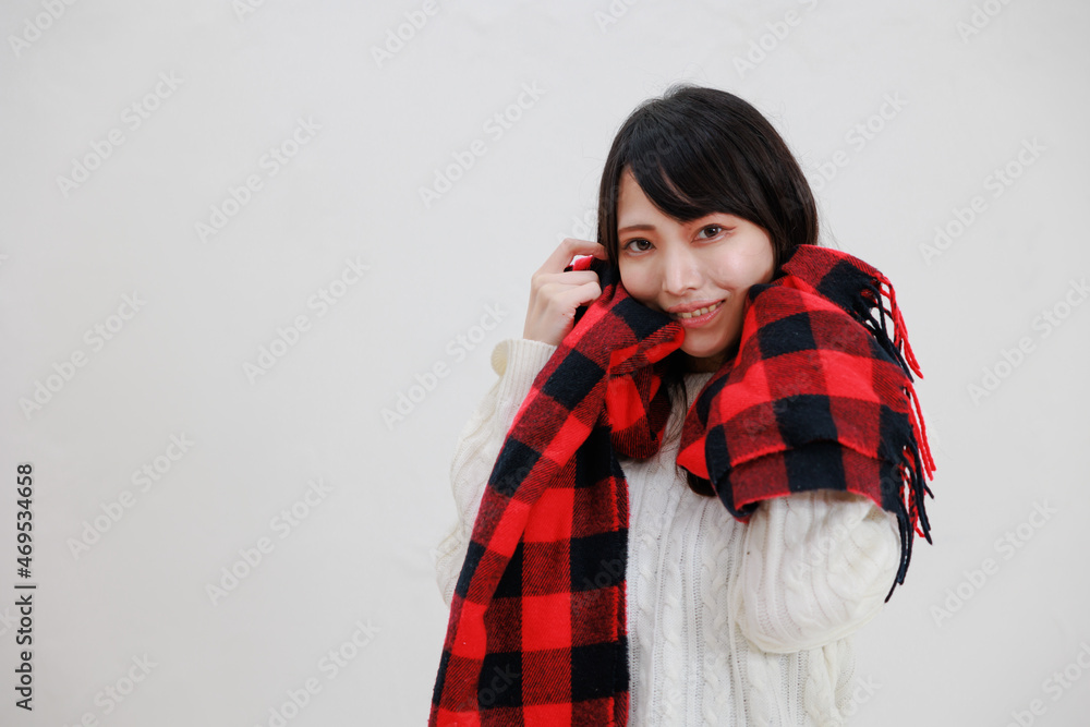 白い背景に赤いマフラーを身に着けている日本人女性 白い背景に赤いマフラーを身に着けている日本人女性