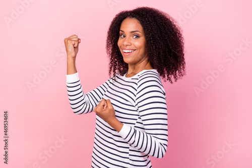 Profile portrait of cheerful pretty lady raise fists yes hooray isolated on pink color background