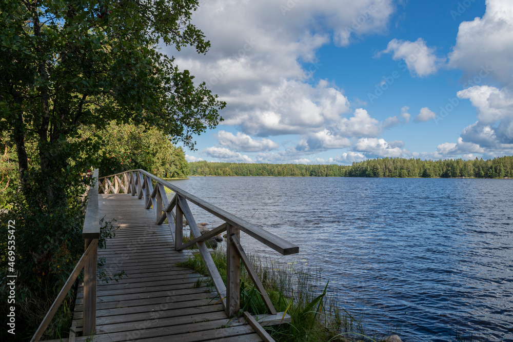 Summer view of Liesjarvi National Park, wooden bridge and lake, Tammela, Finland