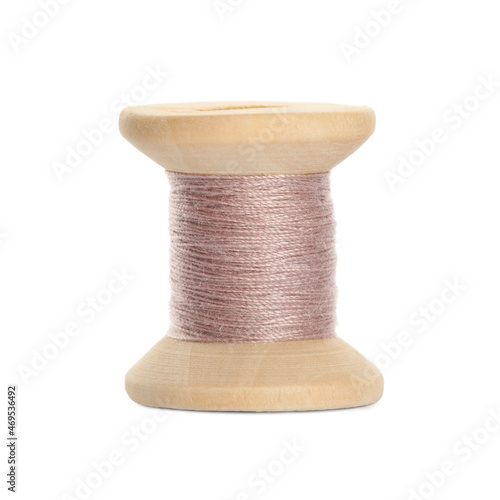 Wooden spool of pink sewing thread isolated on white photo