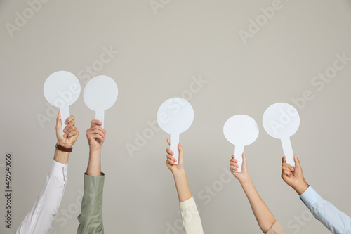 Panel of judges holding blank score signs on beige background, closeup. Space for text photo