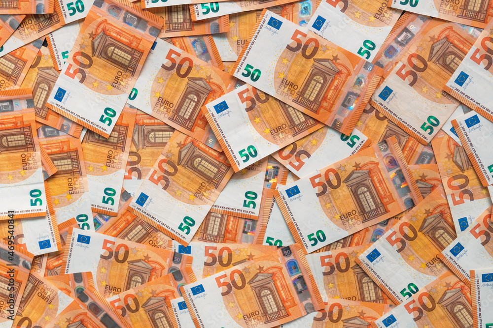 Fifty euros paper banknotes scattered on the table, top view as financial and business background Fifty euros paper banknotes scattered on the table, top view as financial and business background