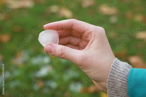 Woman holding hail grain after thunderstorm outdoors, closeup © New Africa