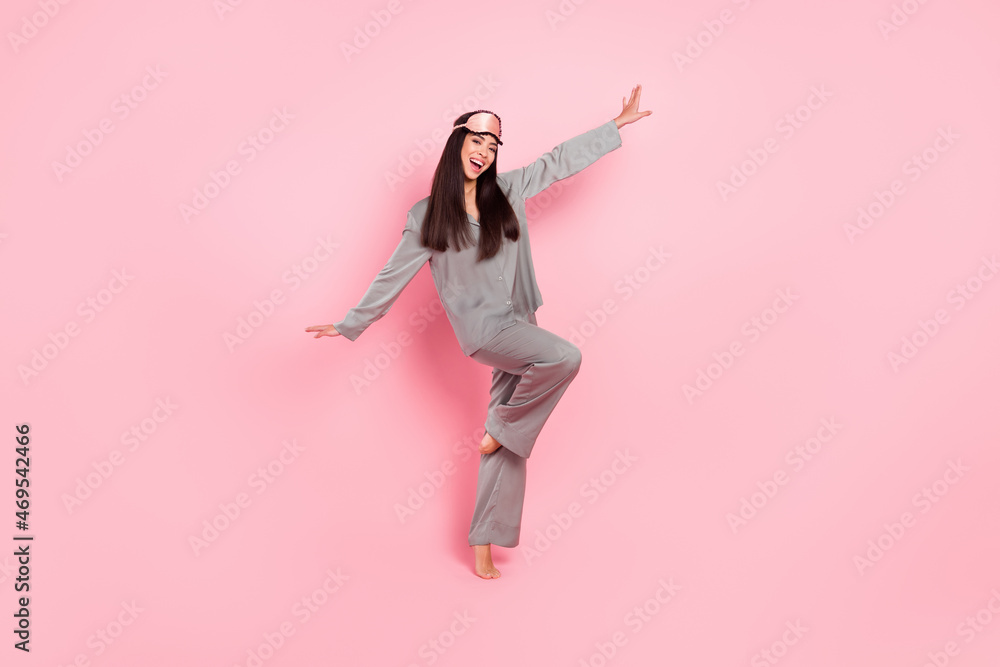 Full length photo of sweet pretty lady sleepwear mask dancing arms sides smiling isolated pink color background