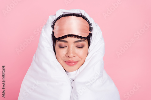 Photo of sweet shiny woman nightwear mask smiling rolling duvet closed eyes isolated pink color background