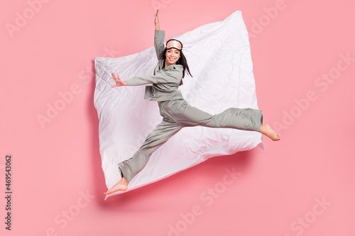 Full length photo of charming pretty lady sleepwear mask jumping high smiling isolated pink color background