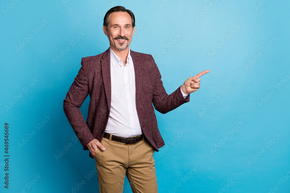 Photo of positive man indicate forefinger empty space wear red blazer isolated blue color background Photo of positive man indicate forefinger empty space wear red blazer isolated blue color background