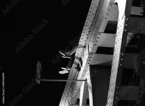 A couple sitting on an Iron bridge at night