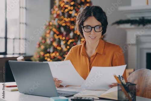 Smiling Hispanic woman employee working in office during christmas time