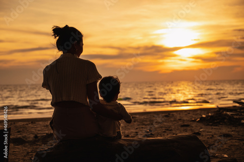 Asian baby and his mother sitting on beach chair with sea beach as background  summer concept