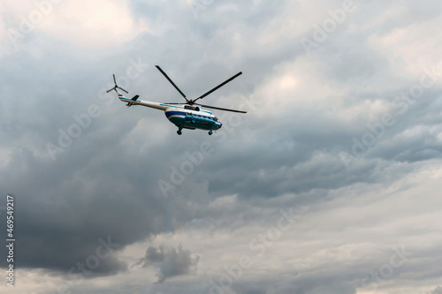 Passenger helicopter Mi-8 flies in the cloudy summer sky. St. Petersburg. Russia