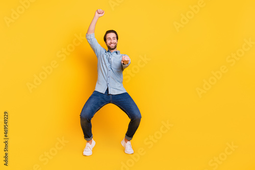 Full length body size photo of crazy man imagine riding horse isolated on vivid yellow color background
