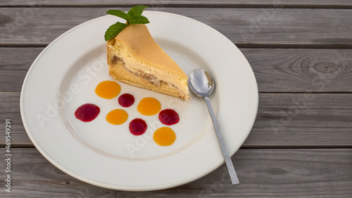 a piece of delicious fresh cake on a large plate with colorful jam drops