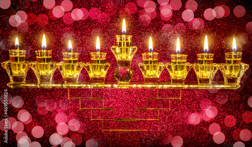 Image depicts Jewish holiday Hanukkah with crystal menorah and burning olive oil candles, festive bokeh blurred background